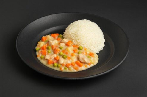 Hühnerfrikassee mit Reis auf Porzellanteller | Catering Berlin
